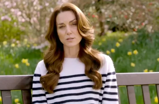 kate middleton body language analysis of her cancer video, still image of her in striped sweater sitting on a park bench in a garden